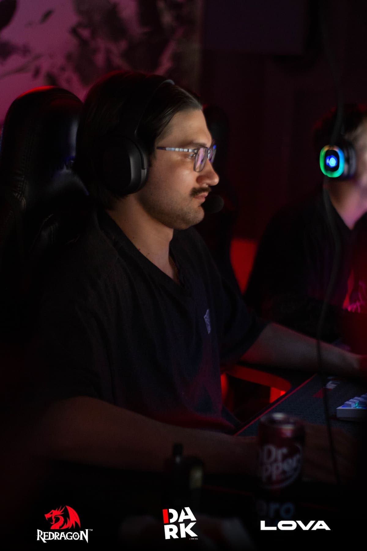 Игрок турнира CS2 Solo Draft в наушниках за компьютером в DARKWALL